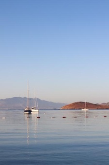 Beautiful sunrise on the aegean sea with islands mountains and boats high quality photo