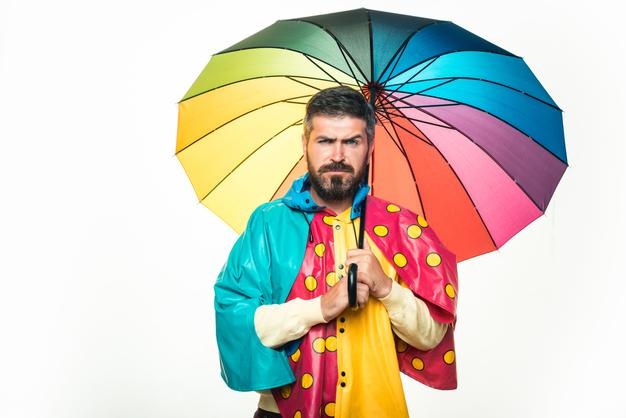 Brutal bearded man with rainbowcolored umbrella isolated on white background rain weather autumn moo...