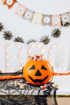 Halloween home decoration with a pumpkin basket filled with candies